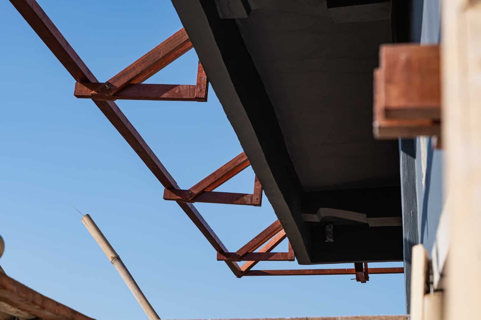 Custom metal roofing structures with wood framing at a construction site.