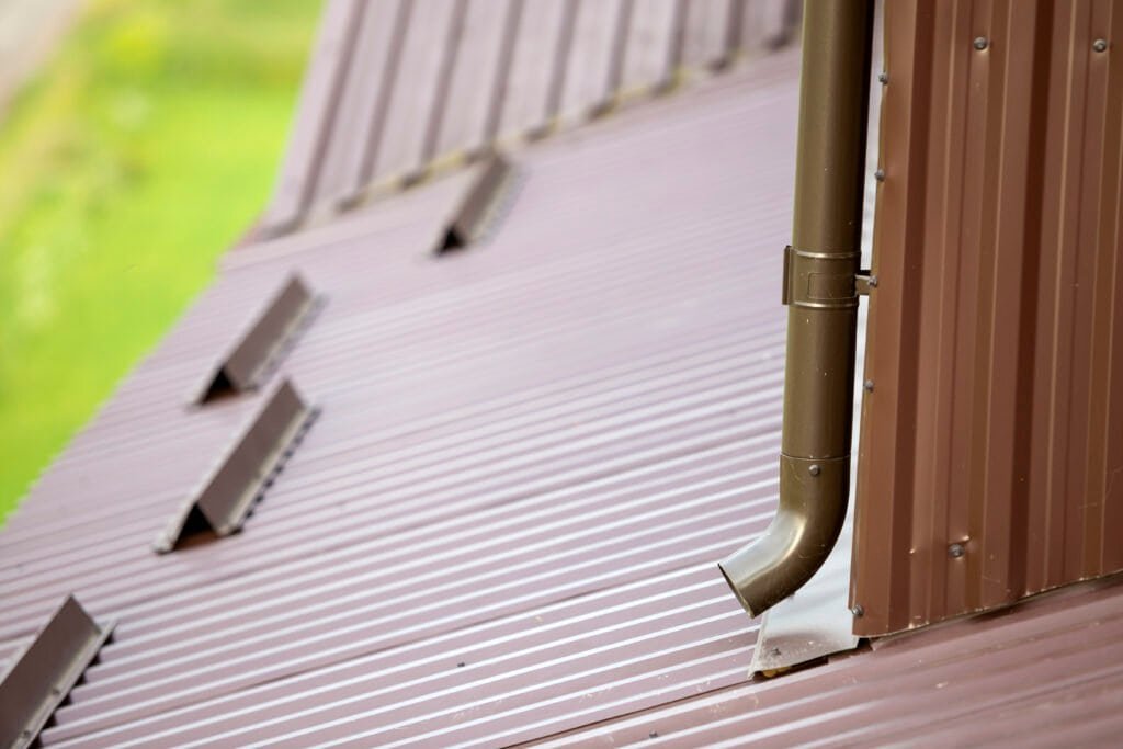 Seamless metal roofing with gutters and downspouts, quality sheet metal installation.