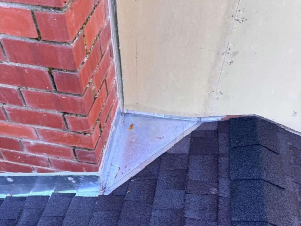 Aluminum flashing installed at roof edge for weather protection.